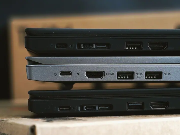 Several laptop computers stacked for handling or resale