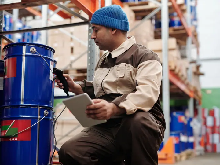 Warehouse employee scanning and checking stored inventory